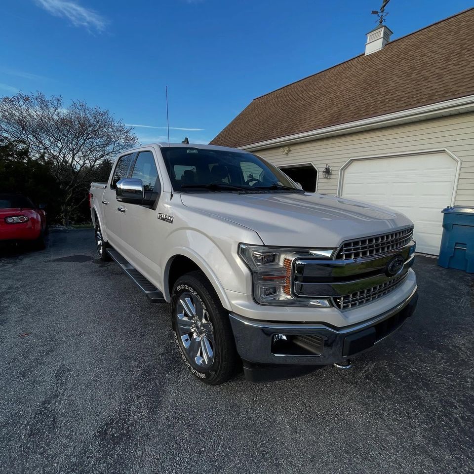 White Ford F-150 Lariat crew cab with chrome grille shining after a driveway detail in Wilmington DE