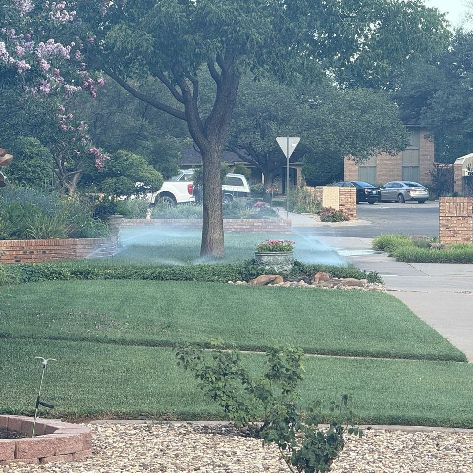 Sprinklers watering a healthy front lawn in Lubbock