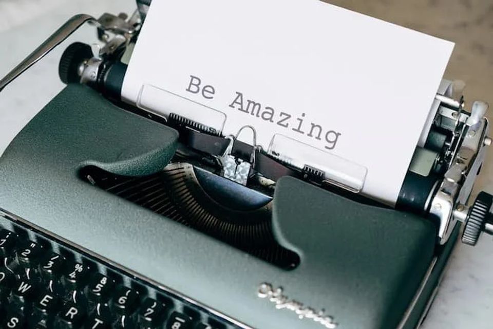Typewriter with a piece of paper coming out saying "Be Amazing." 