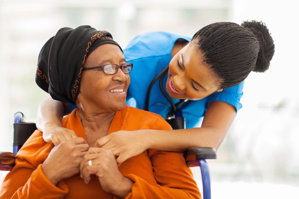 A senior patient and her nurse interacting happily