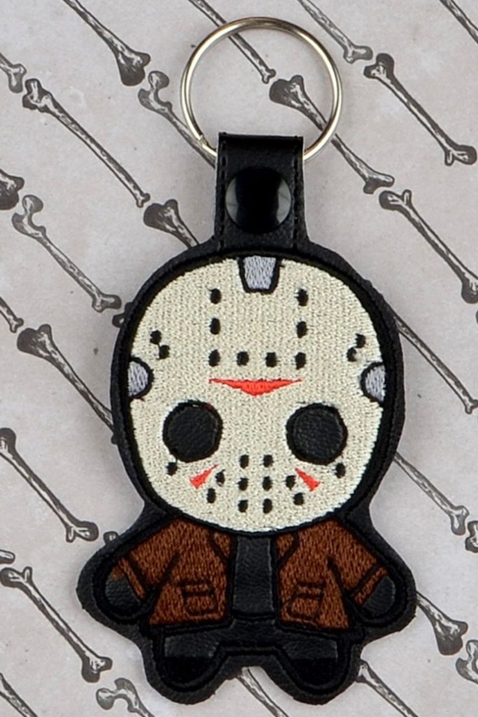 Custom embroidered hockey mask horror keychain with detailed mask artwork and character-inspired design.