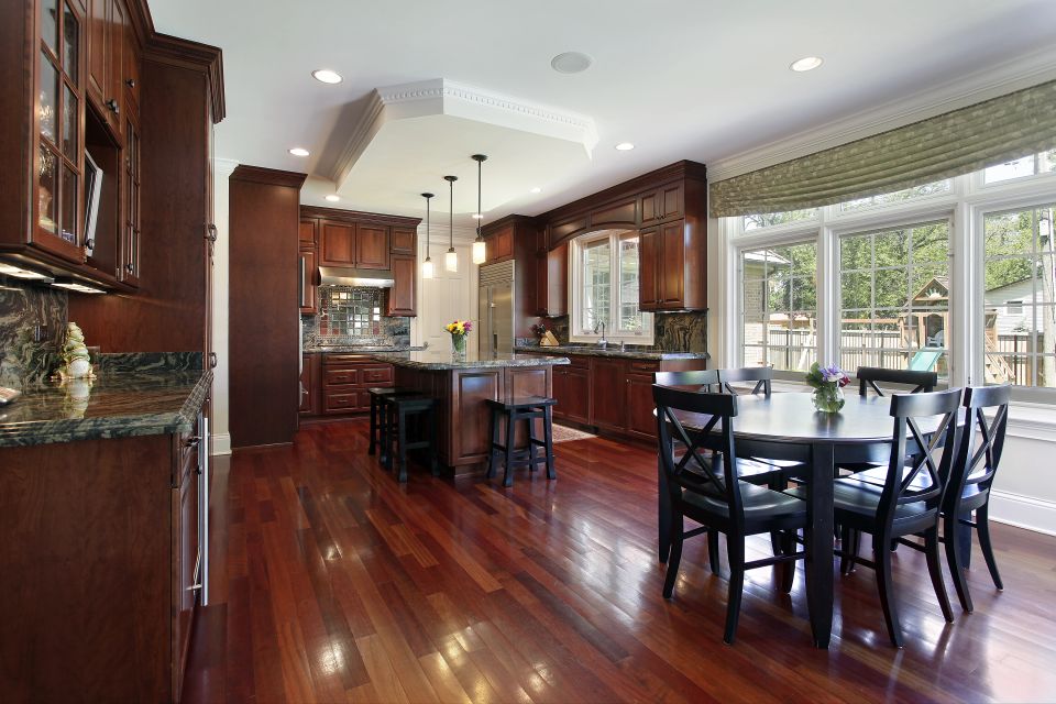 Kitchen with cherry wood cabinetry granite counters and glossy hardwood flooring