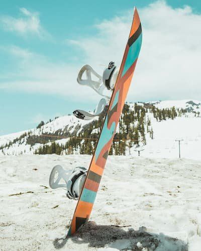 A snowboard stuck into the snow propped up 
