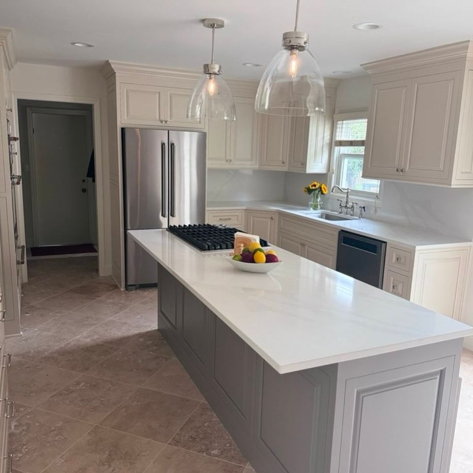 Kitchen remodel with cream cabinets, gray island, and glass pendant lighting in an east side Cleveland home