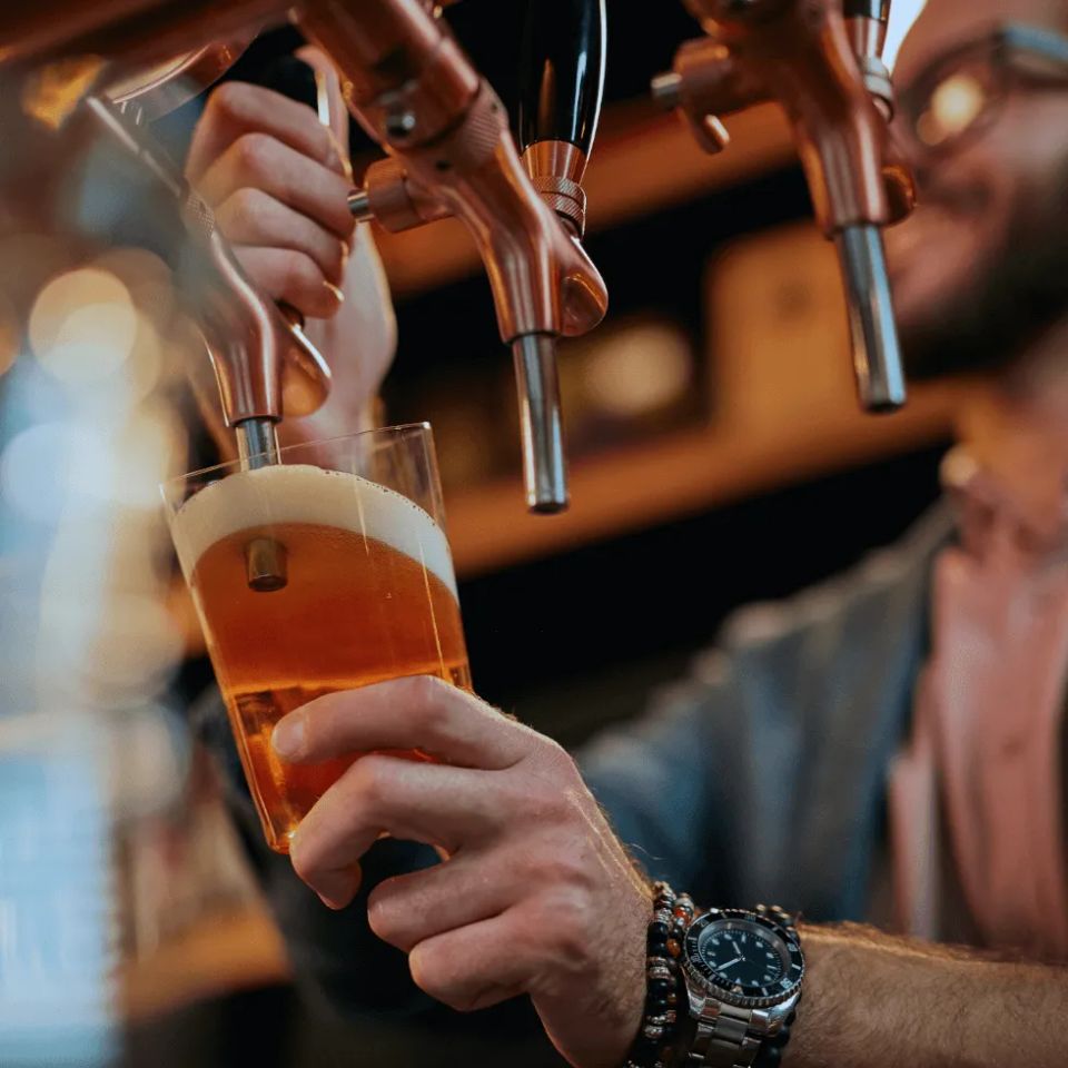 Bartender filling glass with beer