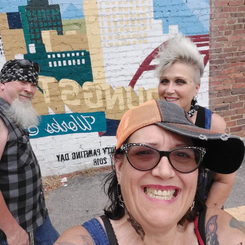 Group of friends taking a selfie in front of a colorful city mural in Youngstown, Ohio.