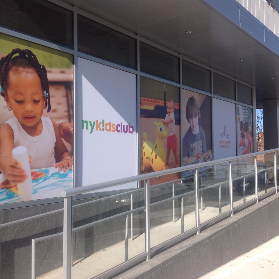 Printed vinyl window graphics with color photography and a logo covering a long glass storefront