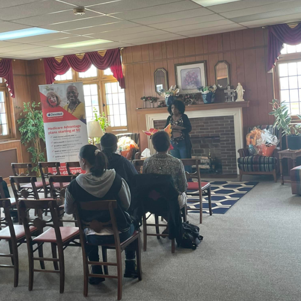 Attendees seated during a church presentation at Grace Evangelistic Temple Church, listening to a speaker in a fellowship room.