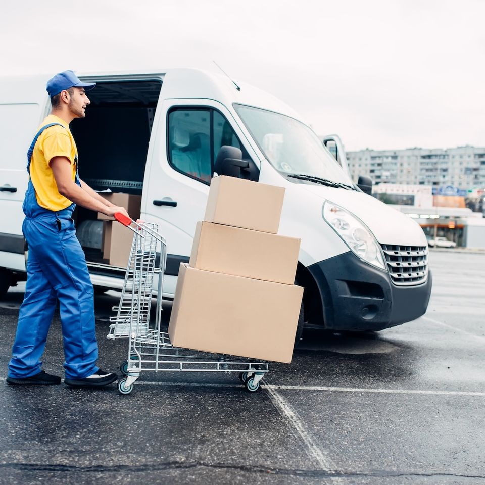 6523d1655c1a2b5a1ef544d4 courier with parcel trolley against logistic truck 2021 08 26 16 25 49 utc