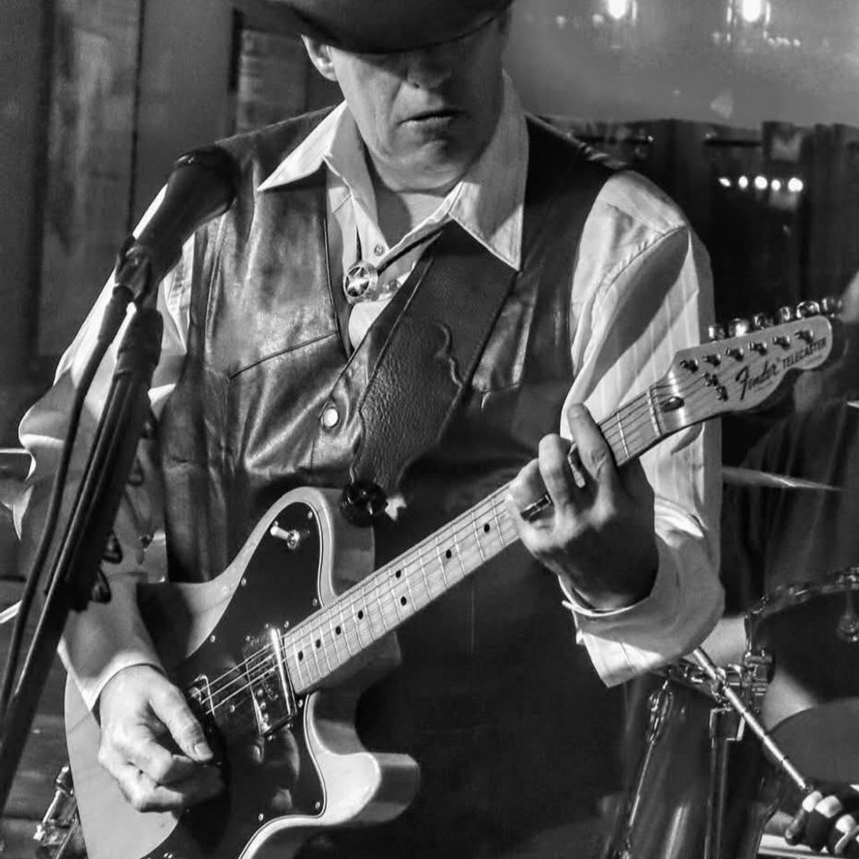 Black and white photo of a Roadside guitarist playing a Fender Telecaster during a live blues set