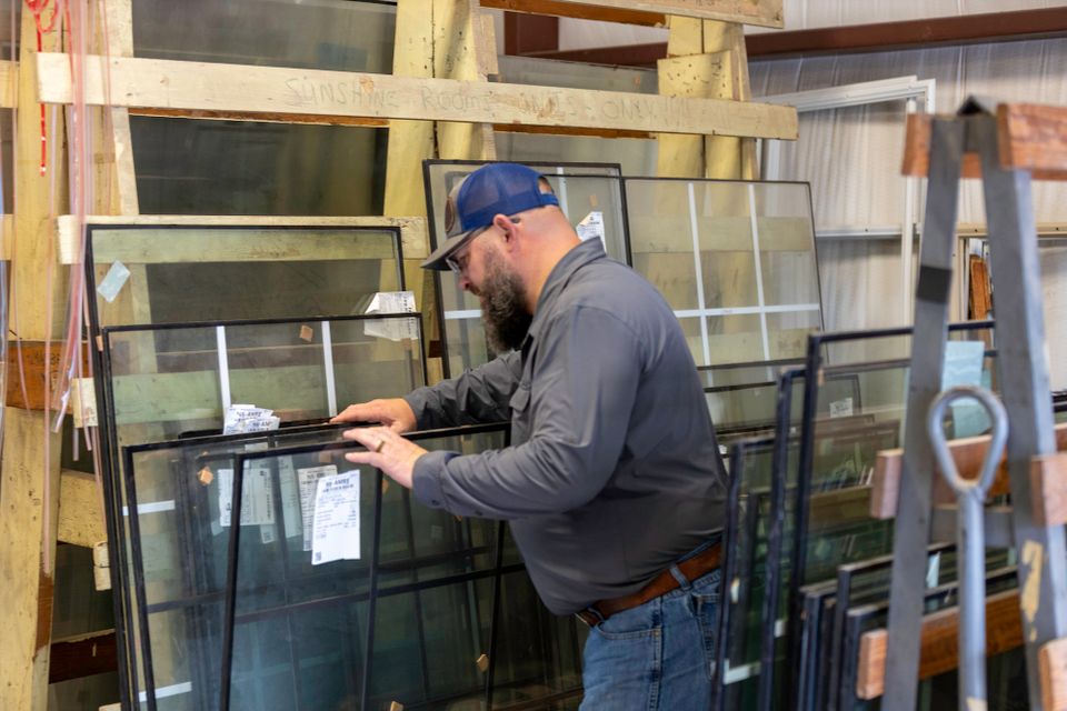 Phillip’s Glass professional inspecting an insulated window glass unit stored in the shop