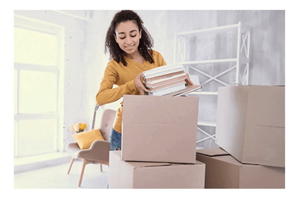 Girl storing belongings in boxes