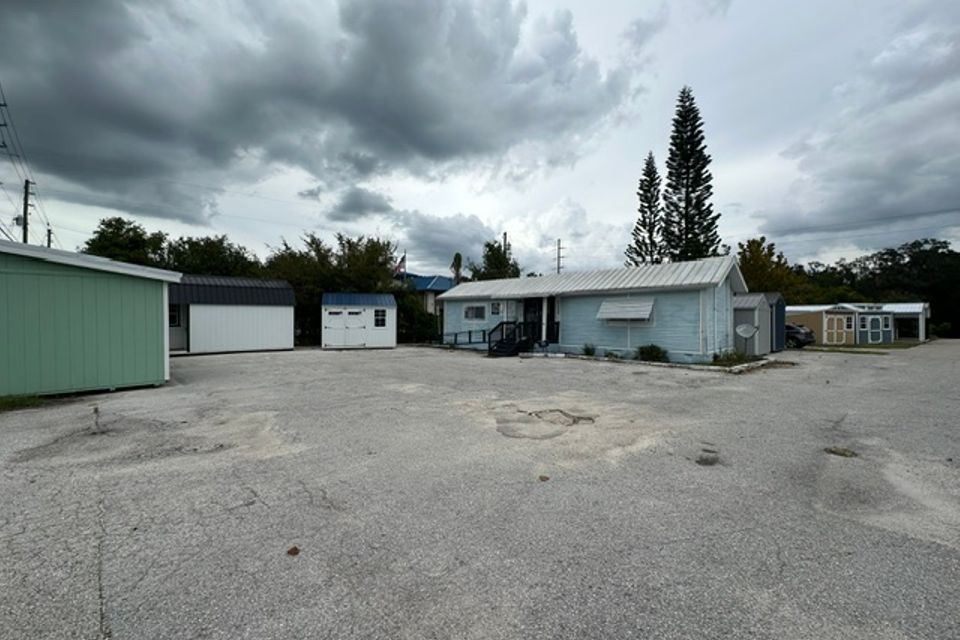 Cluster of steel sheds and buildings on gravel commercial lot under cloudy sky representing steel buildings in Alabama