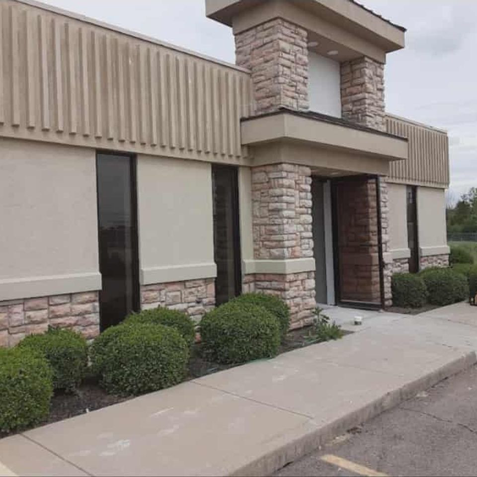 Commercial building featuring decorative veneer stone columns and exterior accents.