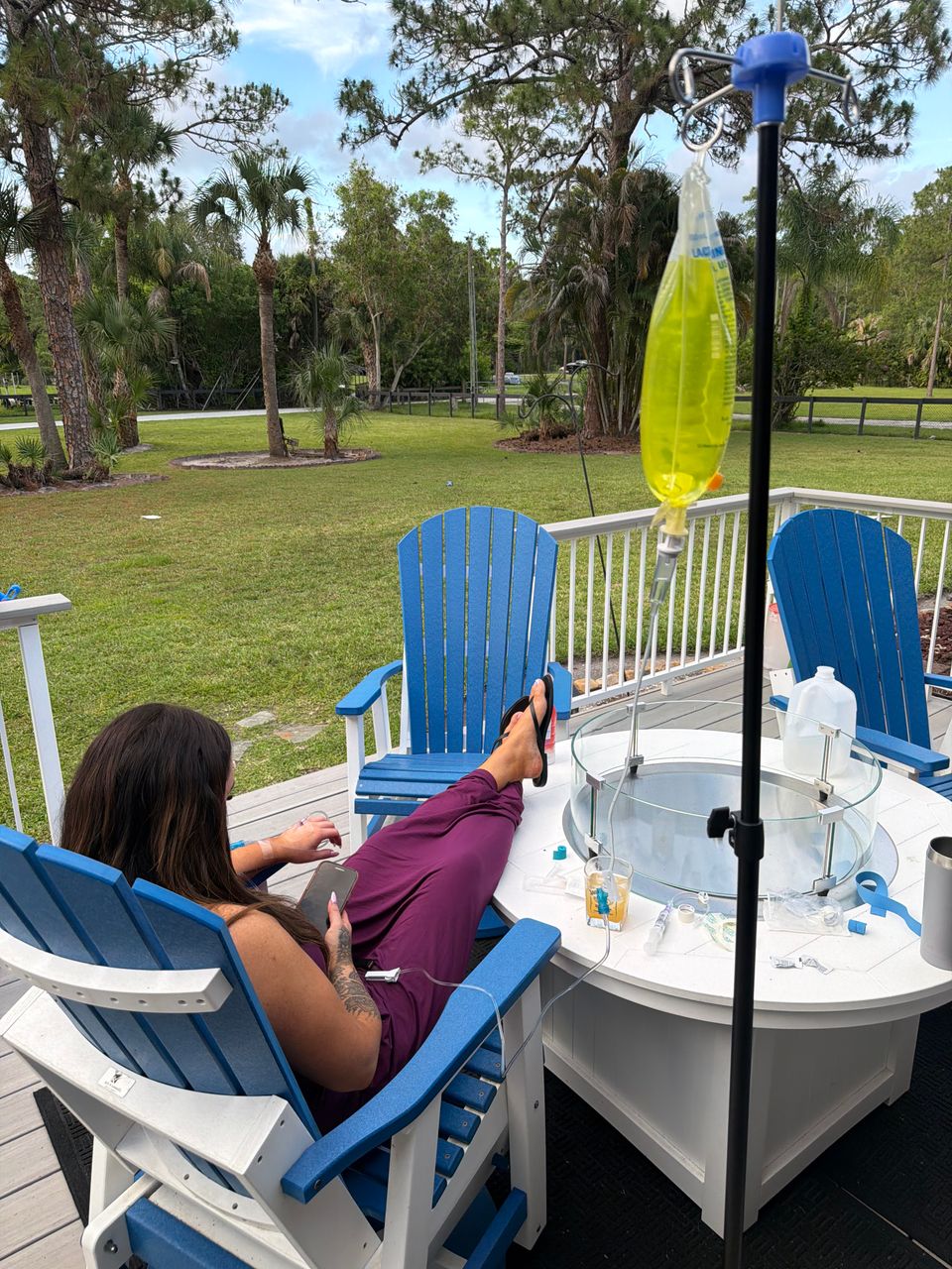Woman receiving a mobile IV vitamin drip while relaxing on a backyard patio in Palm Beach County FL