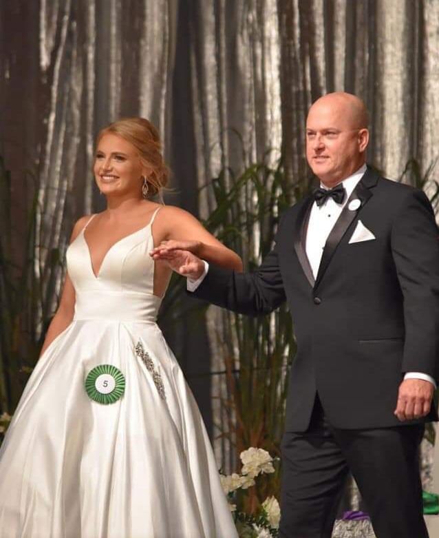 Elegant debutante presentation with escort wearing a black tuxedo and bow tie from New Orleans Tuxedo Inc.