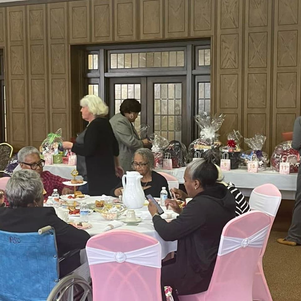 Attendees seated around decorated tables during a fellowship event at Grace Evangelistic Temple Church, sharing a meal and conversation.