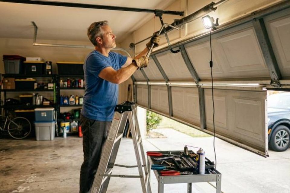 Homeowner in dallas tx adjusting uneven garage door tracks 800x447