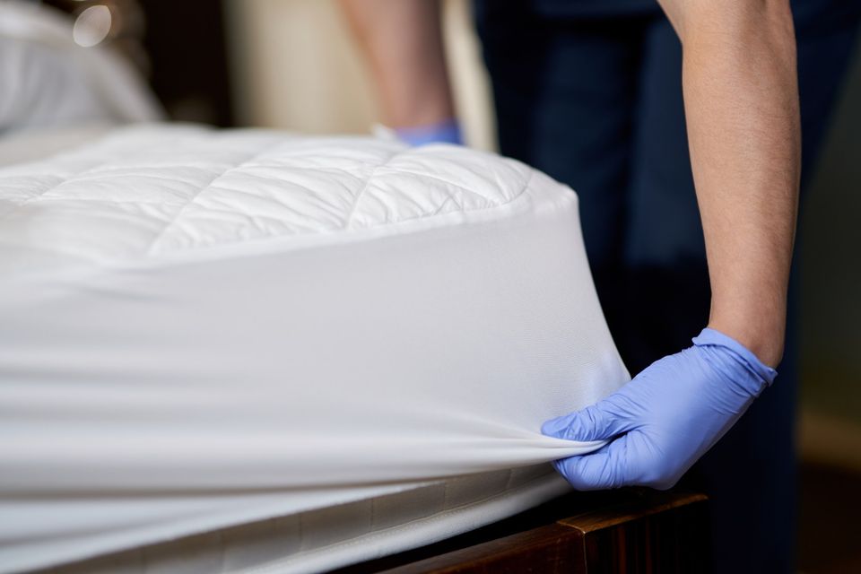 Housekeeper gloves changing bedding hotel room