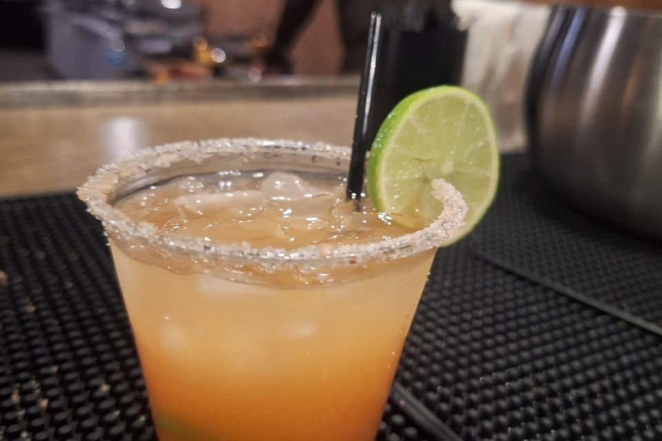 Close-up of a cocktail with lime slice and salted rim on a bar counter