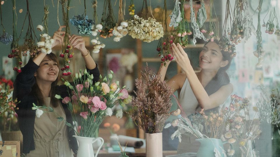 Two smiling business owners in their flower shop