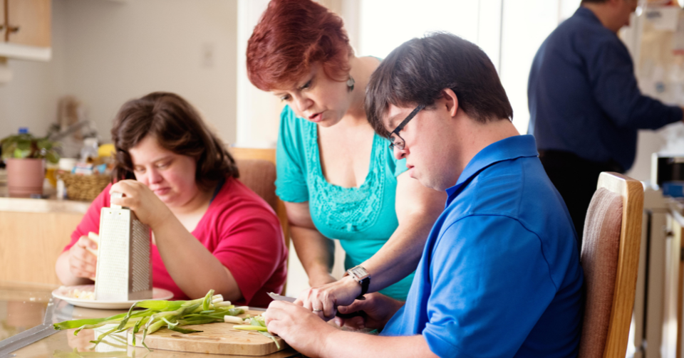 DSAV participant learning food preparation with support from an instructor during a life skills program.