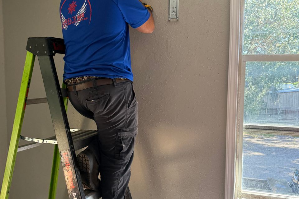 Angels Air has qualified technicians. Here a technician is installing an air conditioner in a customers home.