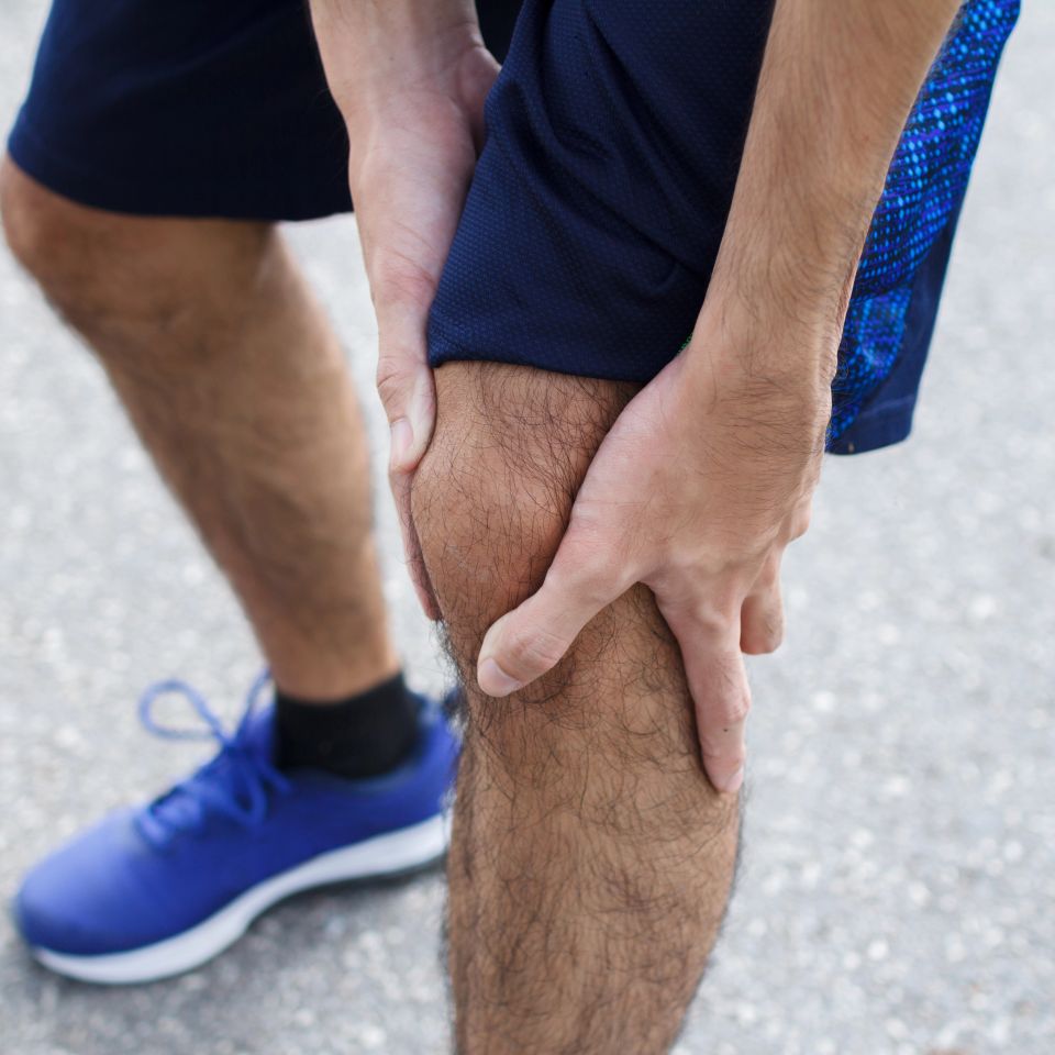Close up of Sport man suffering with pain on sports running knee injury after running
