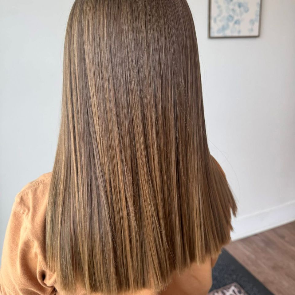 Long sleek straight light brown hair with soft dimensional highlights after color service in Columbiana AL