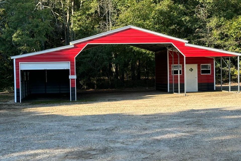 Red and white steel carport barn with open bay and side storage room representing steel carports in Alabama