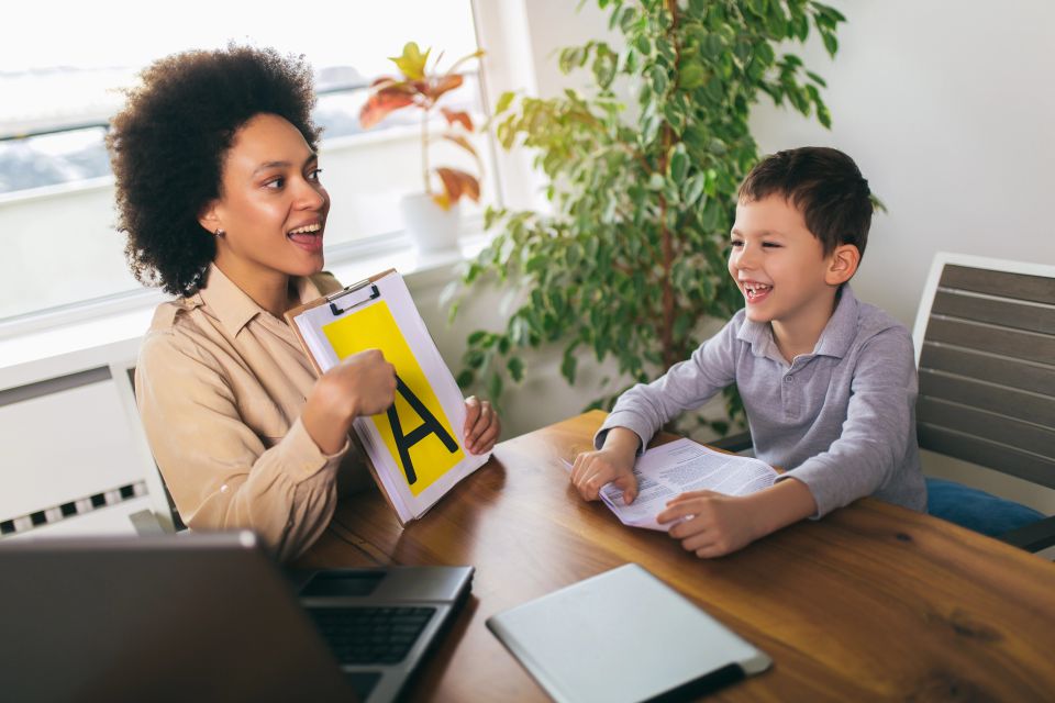 A stock image of a compassionate speech therapist working with a young child in a bright, welcoming office, used in a blog by Cannone Marketing.