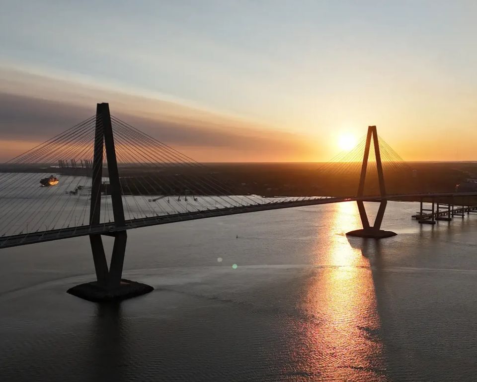 Sunrise view of the Ravenel Bridge and Charleston Harbor from the water during a LowCountry Coastal Excursions boat tour.
