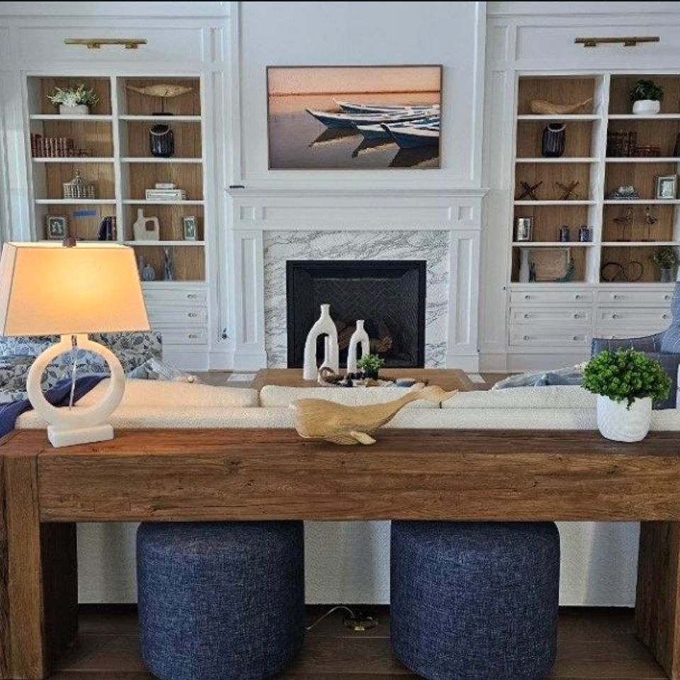 Living room with custom white built in cabinets flanking a marble fireplace