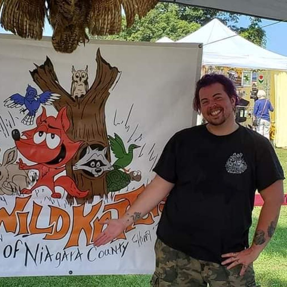 Morty in front of Wild Kritters of Niagara County logo