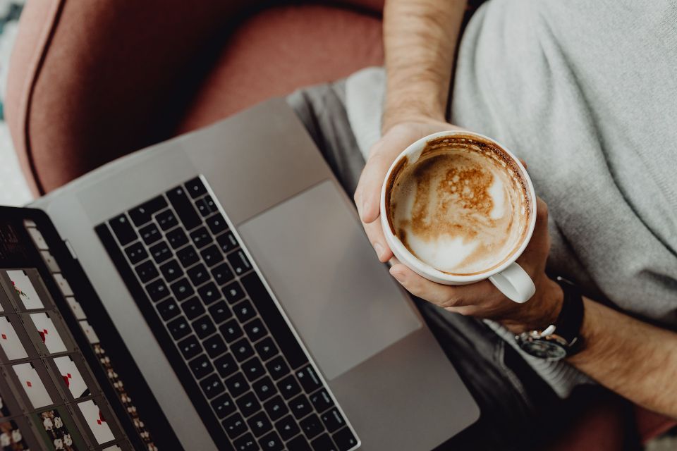 Manager relaxing and having coffee while working on managing staff better