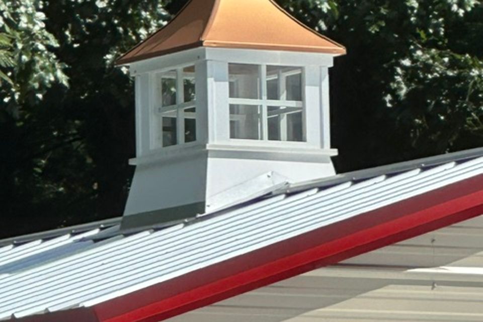 Copper topped cupola on metal roof ridge of steel building representing steel buildings in Alabama