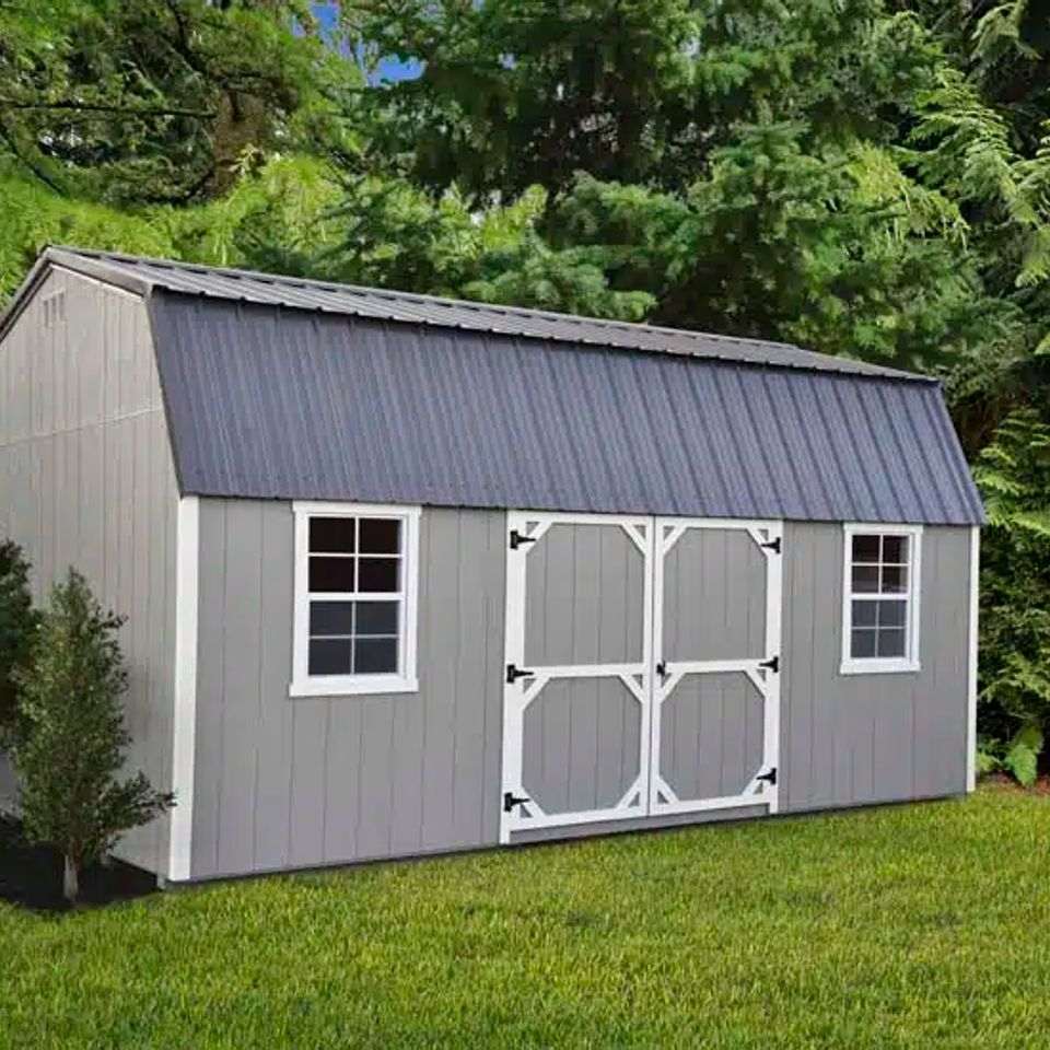 Gray high wall barn shed with white trim, windows and double doors on a Knoxville TN lawn
