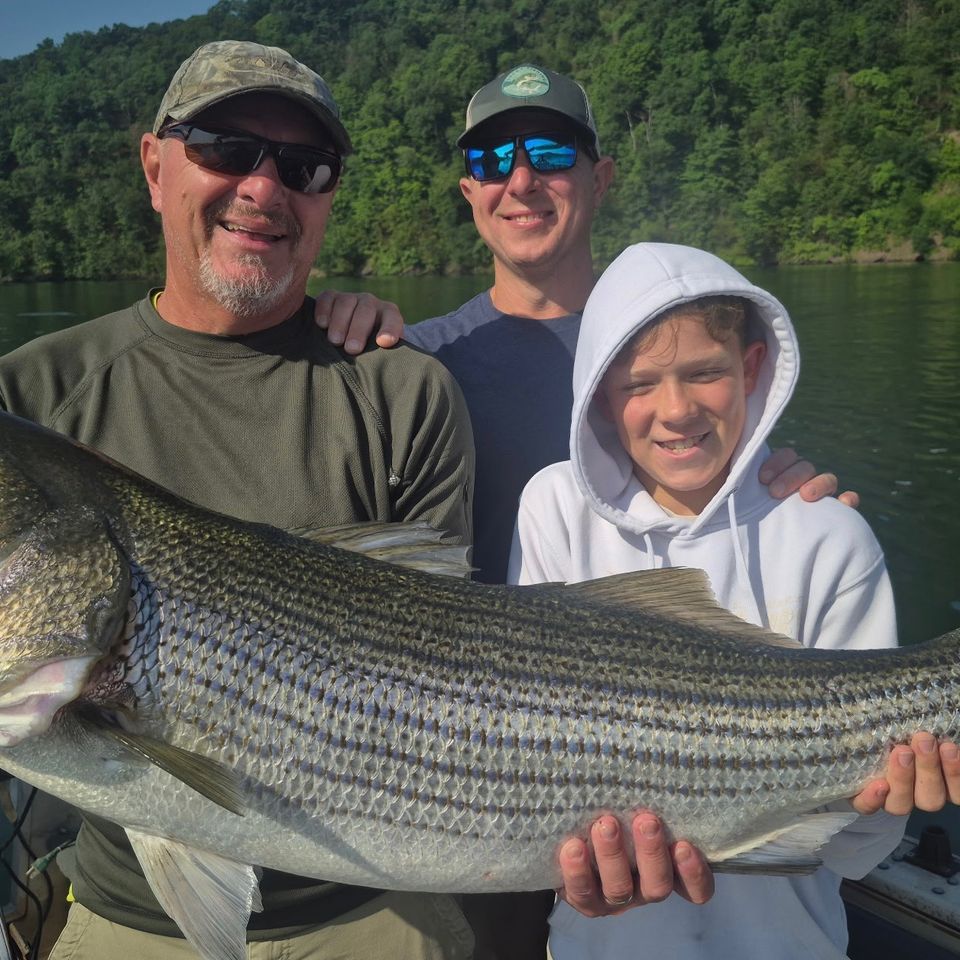 father and sons fishing on lake