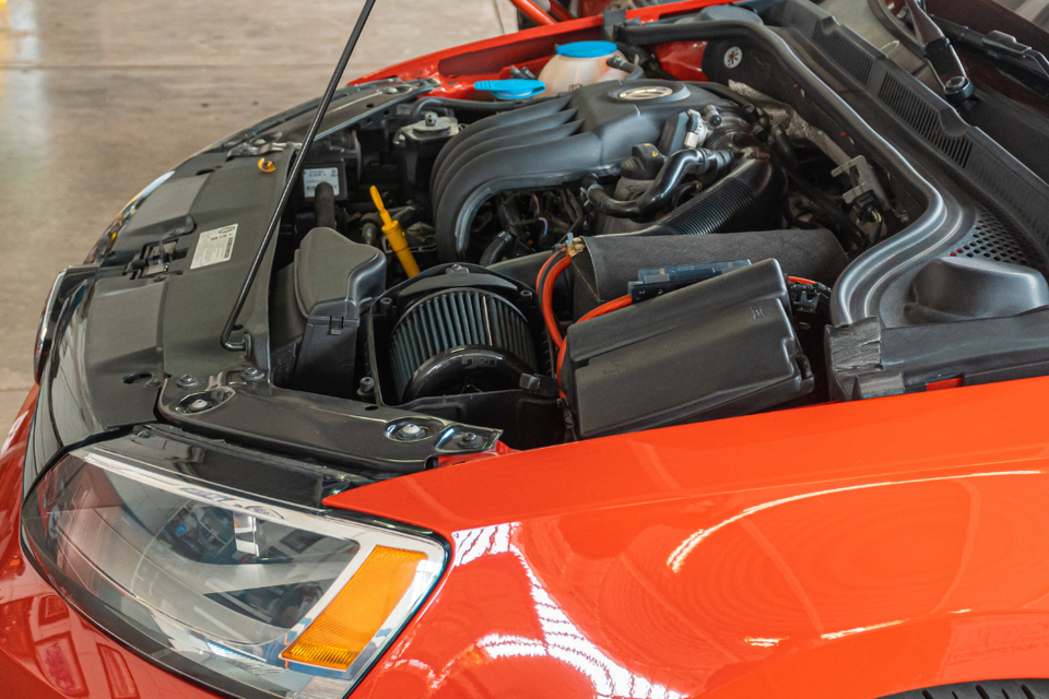 Vehicle engine compartment undergoing engine repair and replacement service.