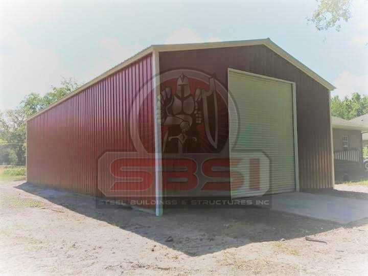 Red and tan steel garage with roll up door and metal roof with SBSI watermark representing steel barns in Alabama
