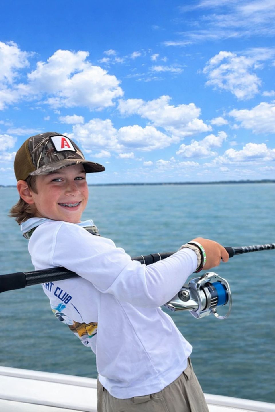 Child fishing on a boat during a kids fishing camp in Charleston, South Carolina with LowCountry Coastal Excursions