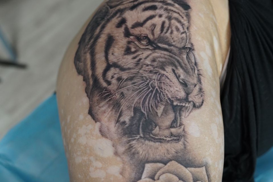 Image of a tiger's head in black and white with a flower below and above him