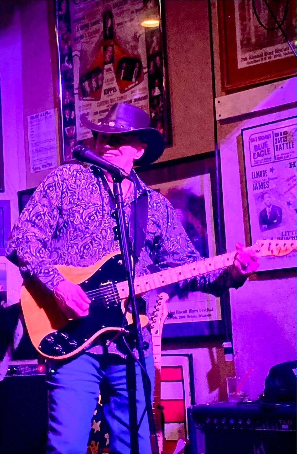 Roadside guitarist in a cowboy hat playing electric guitar during a live blues and Americana set