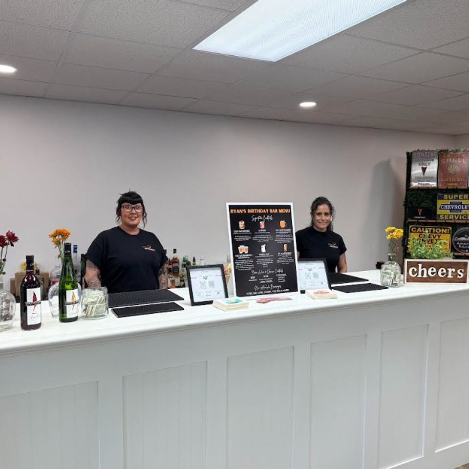 Full bar setup with staff and owner ready for service at a birthday celebration event