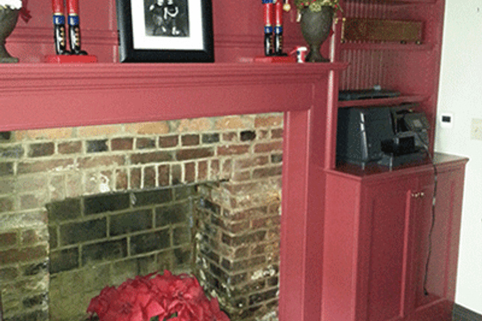 Fireplace with red cabinet before