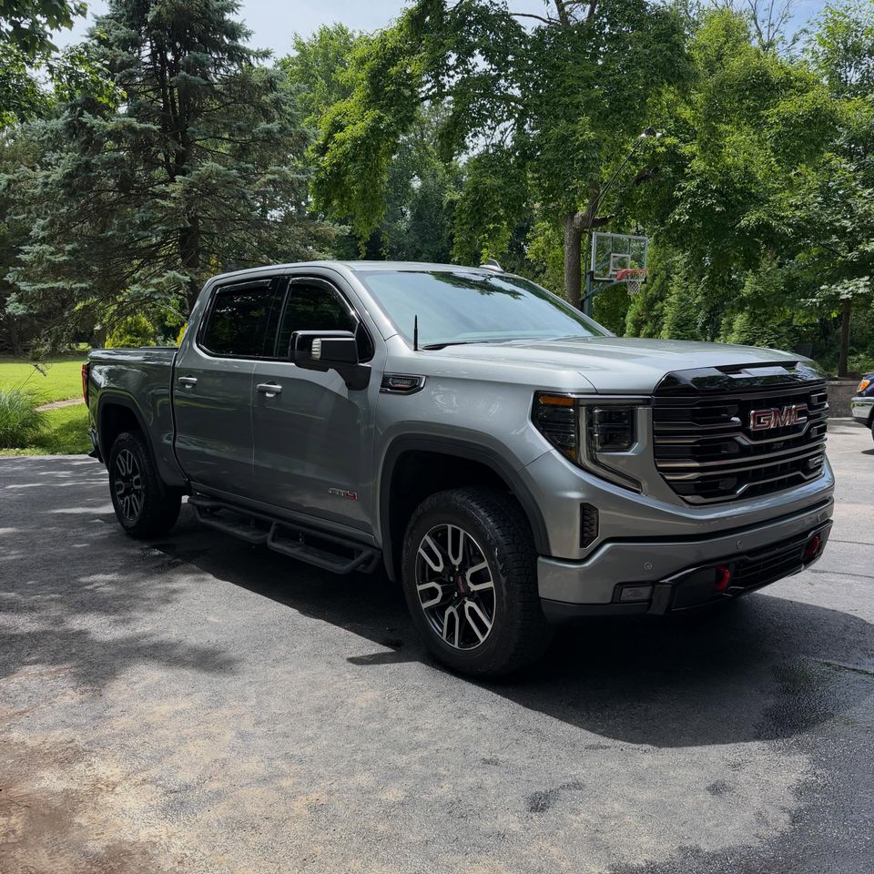 GMC Sierra AT4 pickup with black running boards and freshly washed paint after an exterior detail