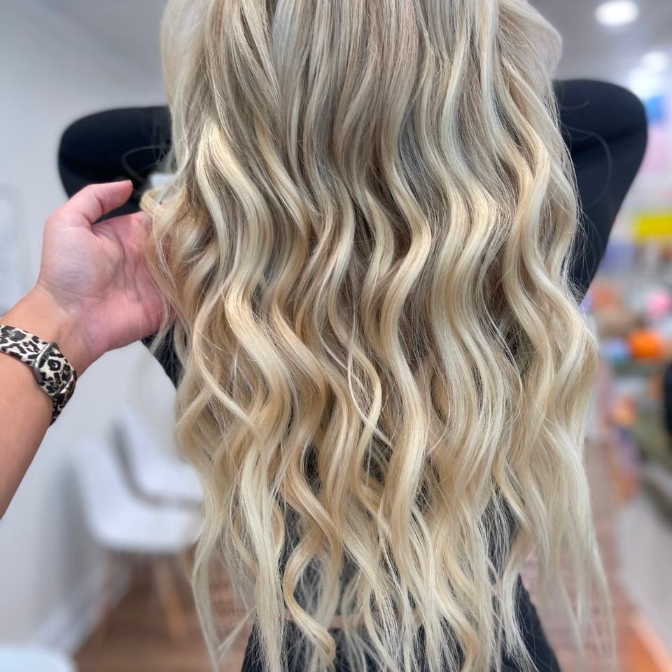 Long wavy platinum blonde hair with soft dimension after color and styling in Columbiana AL