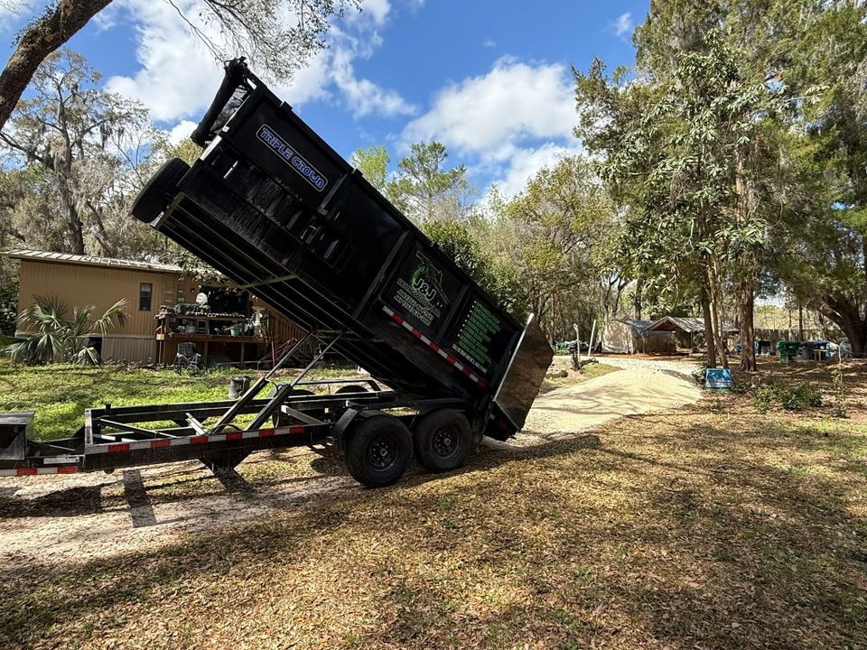 JNJ Hauling Solutions dumpster in the downward emptying position