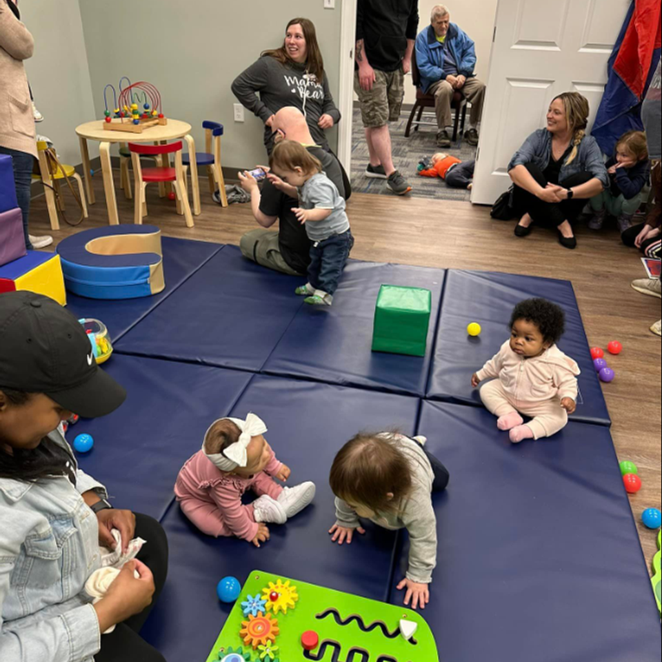 Families and young children participating in an early childhood play group hosted by the Down Syndrome Association of the Valley.