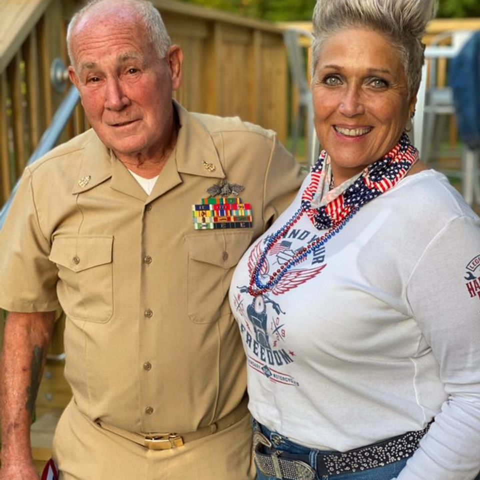 Kelly posing beside a veteran in military dress uniform at a patriotic community gathering.